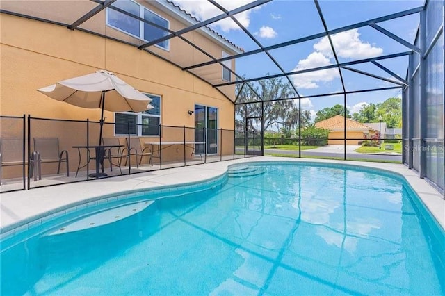 view of swimming pool featuring a patio area and glass enclosure