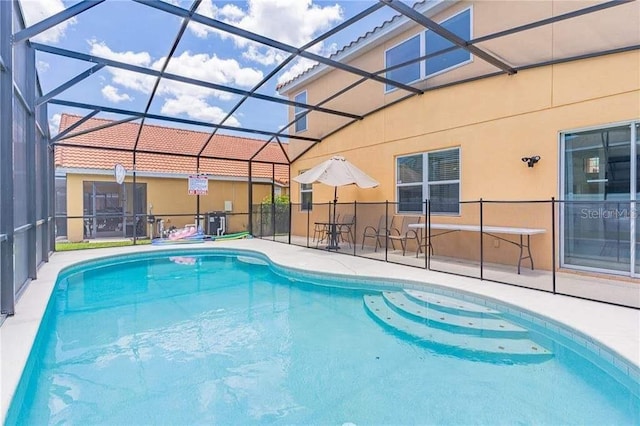 view of pool featuring glass enclosure and a patio