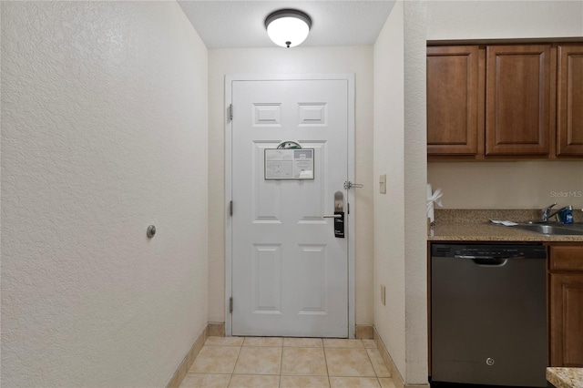 doorway to outside with sink and light tile patterned flooring