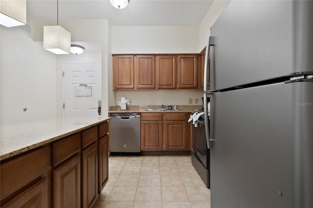 kitchen with stainless steel appliances, sink, decorative light fixtures, light tile patterned floors, and light stone countertops