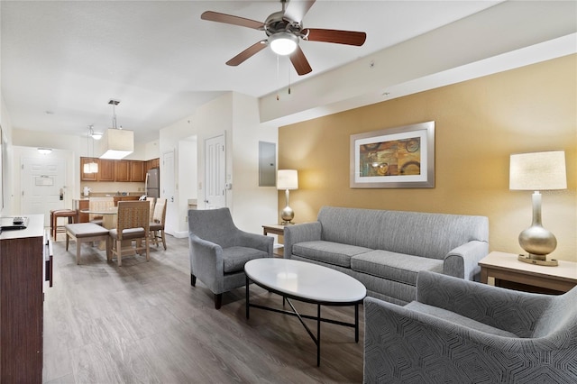 living room featuring electric panel, ceiling fan, and hardwood / wood-style flooring