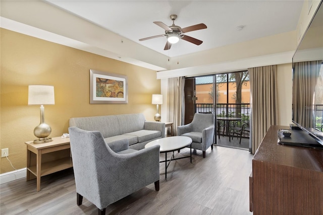 living room featuring ceiling fan and hardwood / wood-style floors