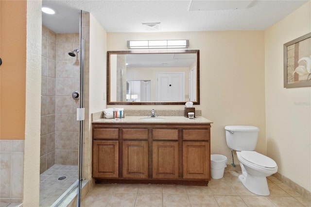 bathroom with a textured ceiling, an enclosed shower, vanity, and toilet