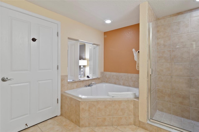 bathroom with tile patterned flooring, a textured ceiling, and separate shower and tub