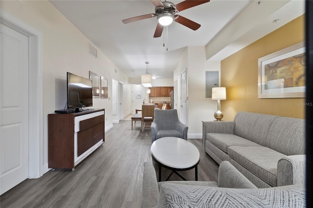 living room featuring ceiling fan and dark hardwood / wood-style flooring