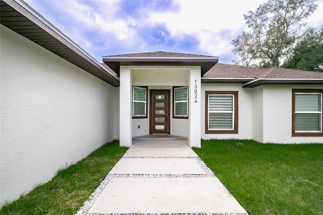 entrance to property featuring a yard