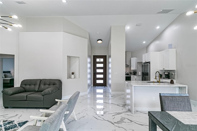 interior space featuring sink, a notable chandelier, and a towering ceiling