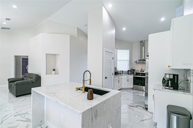 kitchen with light stone countertops, wall chimney exhaust hood, white cabinetry, sink, and stainless steel electric range