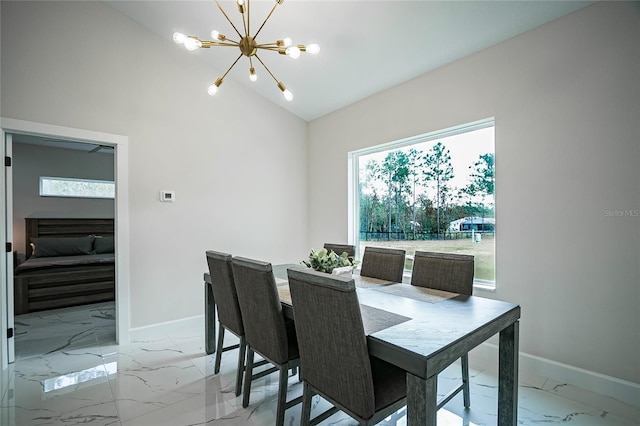 dining space featuring lofted ceiling, a fireplace, and a chandelier