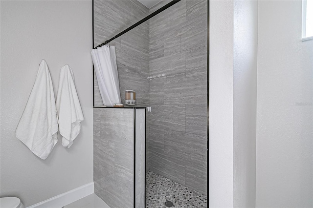 bathroom featuring toilet and curtained shower