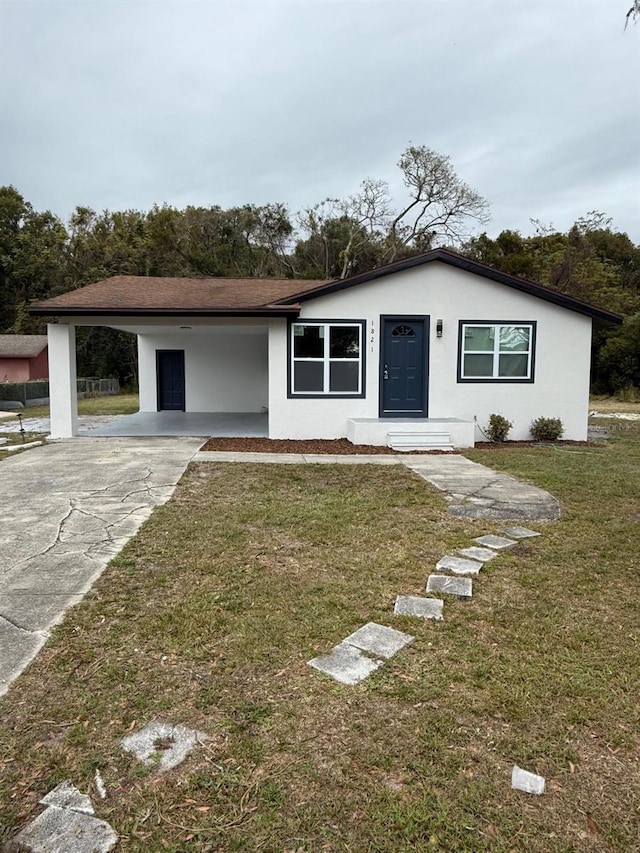 single story home featuring a carport and a front lawn