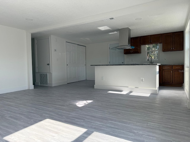 unfurnished living room featuring sink, a textured ceiling, and light hardwood / wood-style floors