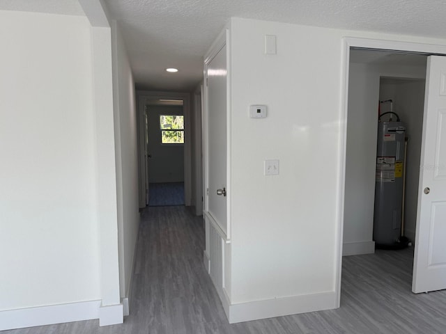 hall with electric water heater and wood-type flooring