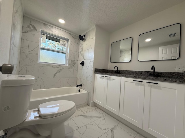 full bathroom featuring a textured ceiling, vanity, tiled shower / bath combo, and toilet