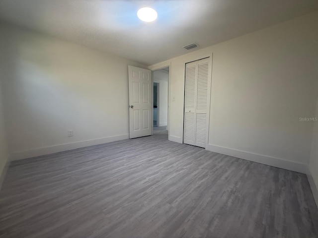 unfurnished bedroom featuring a closet and hardwood / wood-style flooring