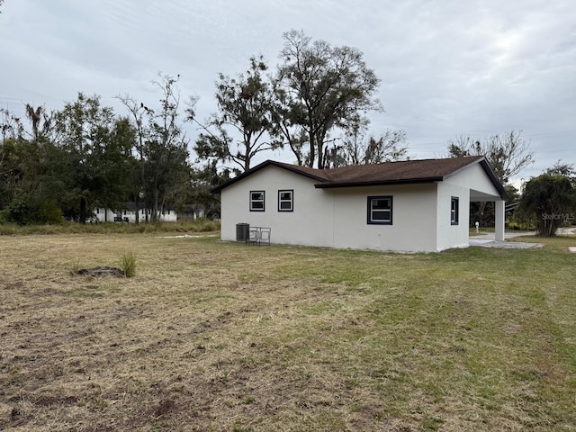 view of side of property featuring cooling unit and a lawn