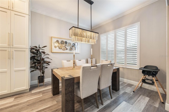 dining area featuring a chandelier, a wealth of natural light, ornamental molding, and light hardwood / wood-style flooring