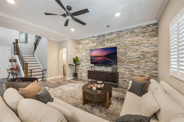 living room with ceiling fan, crown molding, a textured ceiling, and hardwood / wood-style flooring