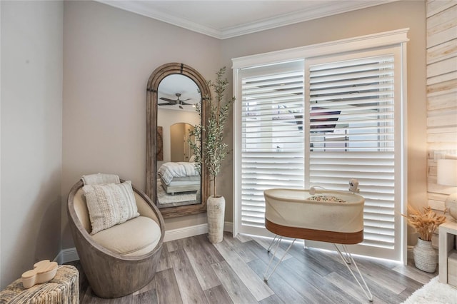 living area featuring light wood-type flooring, ceiling fan, and ornamental molding