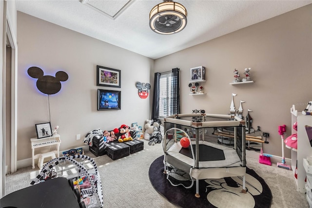 playroom featuring a textured ceiling and carpet flooring