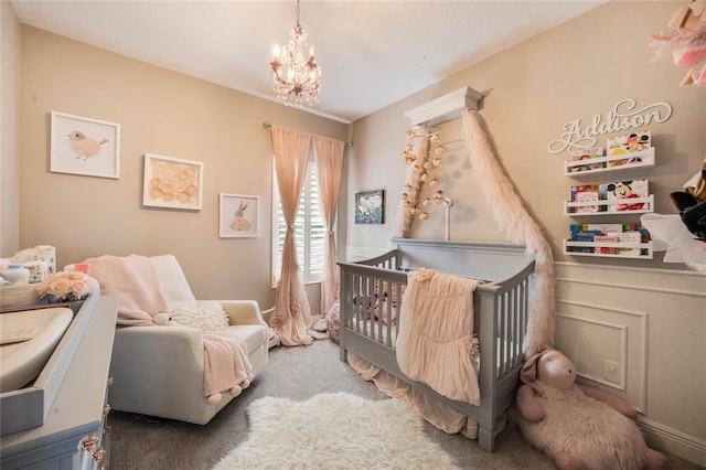 bedroom featuring light carpet, a notable chandelier, and a crib