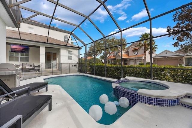 view of pool featuring an in ground hot tub, a patio area, glass enclosure, and grilling area