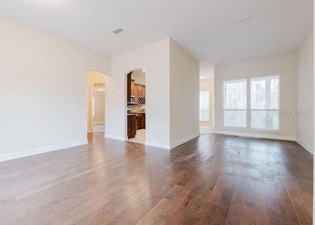 interior space featuring a textured ceiling and dark hardwood / wood-style flooring