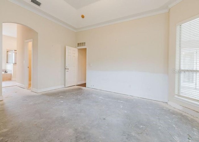 empty room featuring concrete floors, ornamental molding, and plenty of natural light