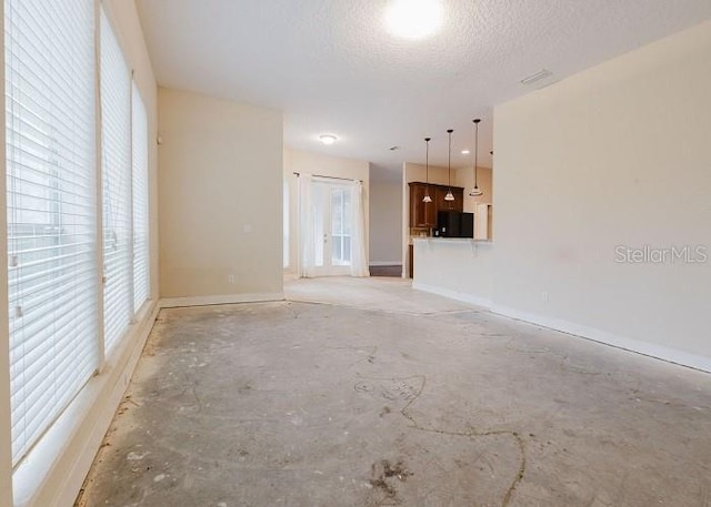 spare room with a textured ceiling and a healthy amount of sunlight