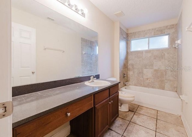 full bathroom with toilet, a textured ceiling, tile patterned floors, tiled shower / bath, and vanity