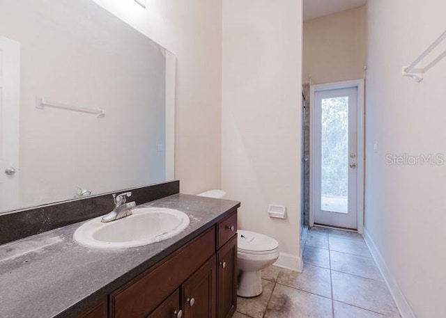 bathroom featuring toilet, tile patterned flooring, and vanity