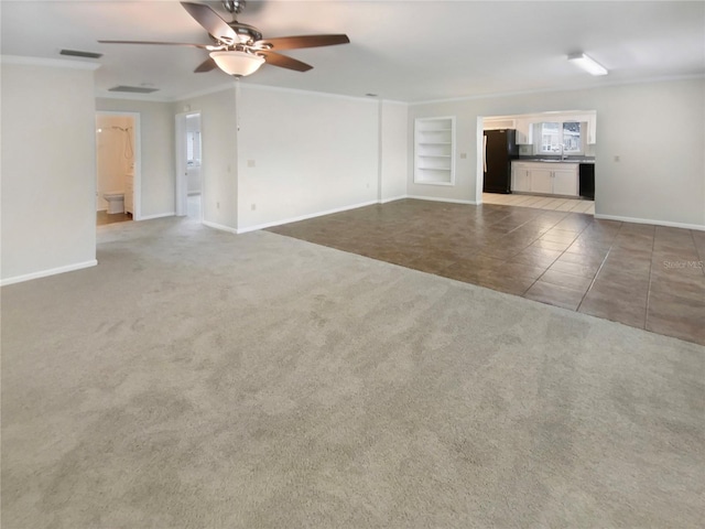 unfurnished living room featuring ceiling fan, built in shelves, tile patterned floors, and ornamental molding