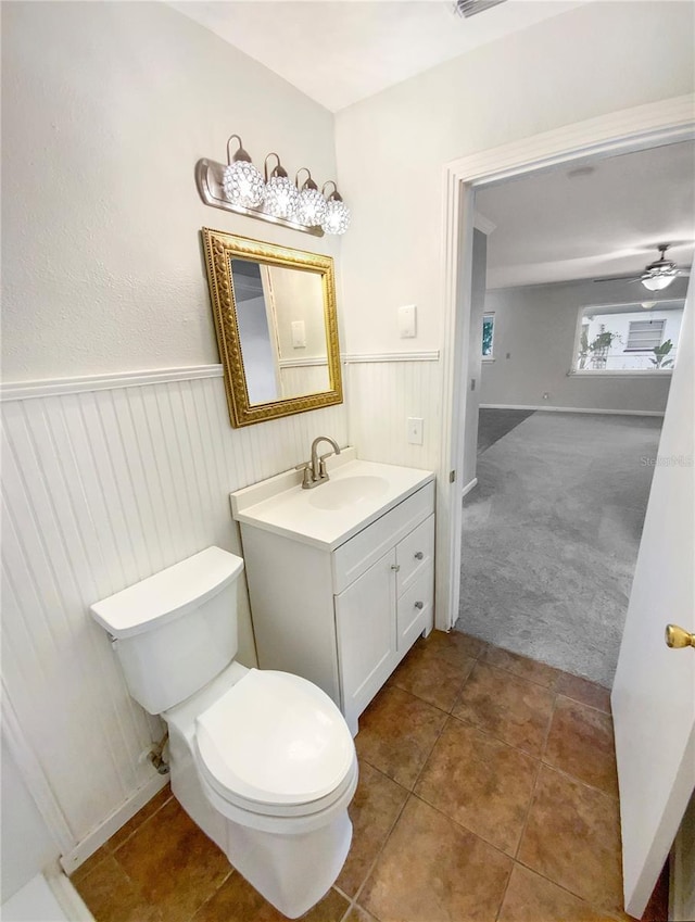 bathroom with toilet, vanity, tile patterned flooring, and ceiling fan