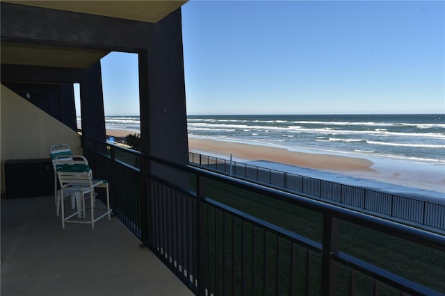 balcony featuring a water view and a view of the beach