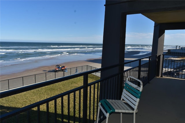 balcony with a water view and a view of the beach