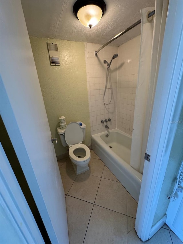 bathroom featuring a textured ceiling, toilet, tile patterned floors, and shower / tub combo with curtain