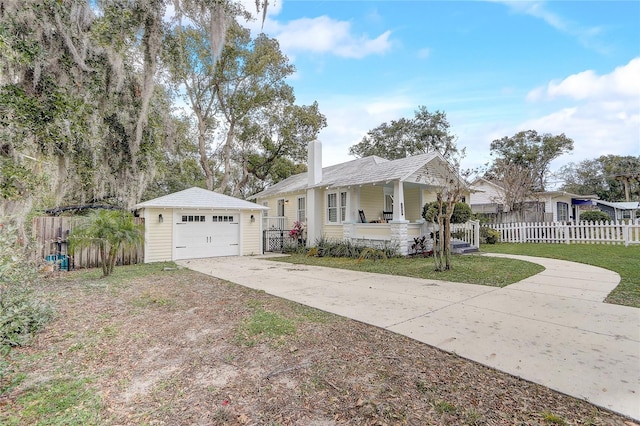 ranch-style home featuring a garage, a front lawn, an outdoor structure, and a porch