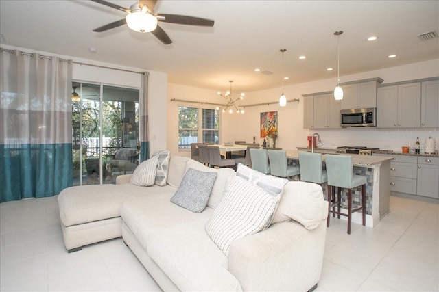 living room featuring ceiling fan with notable chandelier