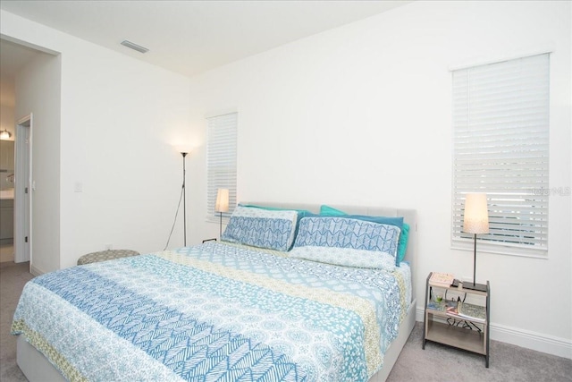 carpeted bedroom featuring connected bathroom