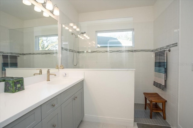 bathroom featuring tiled shower, tile patterned floors, and vanity