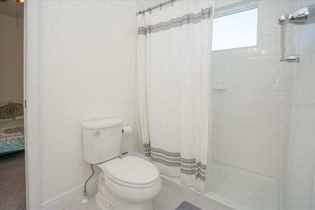 bathroom featuring toilet and a shower with shower curtain