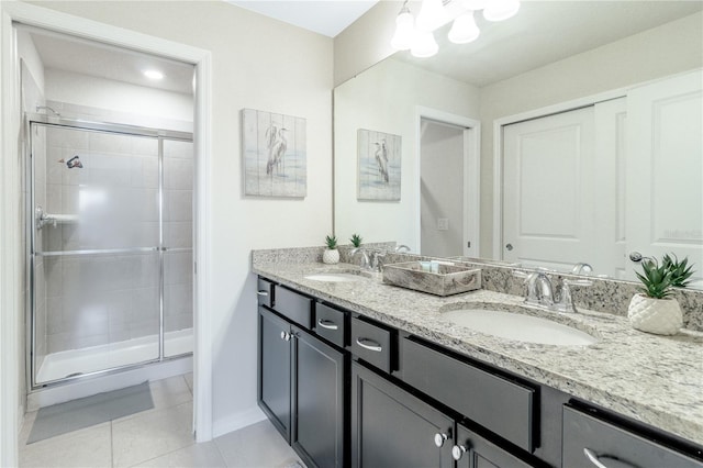 bathroom with tile patterned flooring, a shower with door, and vanity