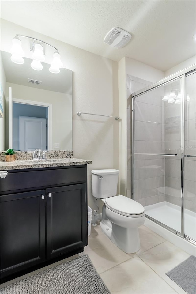 bathroom featuring toilet, a shower with shower door, tile patterned floors, a textured ceiling, and vanity