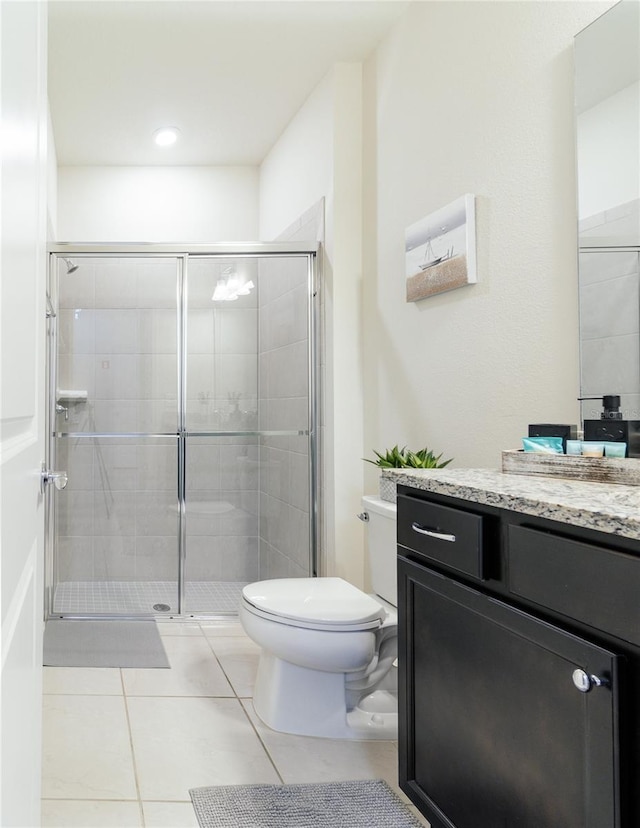 bathroom with toilet, tile patterned floors, an enclosed shower, and vanity