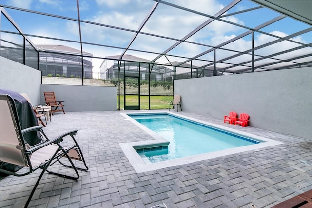 view of pool with a patio area and glass enclosure