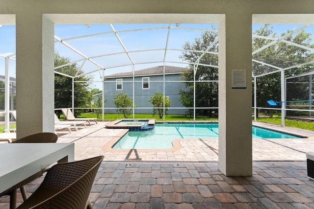 view of pool featuring an in ground hot tub, a lanai, and a patio