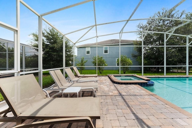 view of swimming pool with an in ground hot tub, a patio area, and glass enclosure