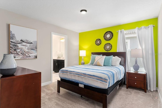 carpeted bedroom featuring ensuite bath