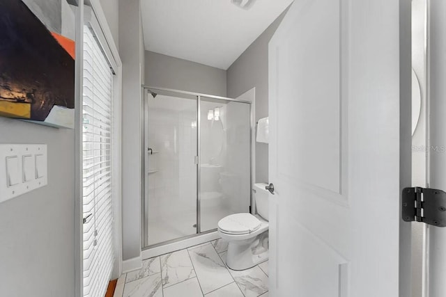 bathroom with toilet and a shower with shower door