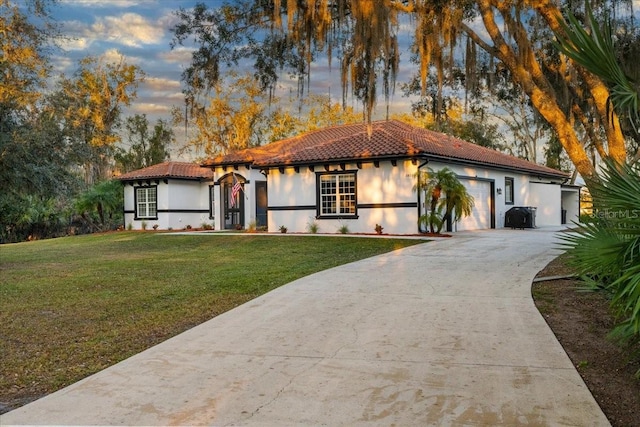 mediterranean / spanish-style house with a yard and a garage